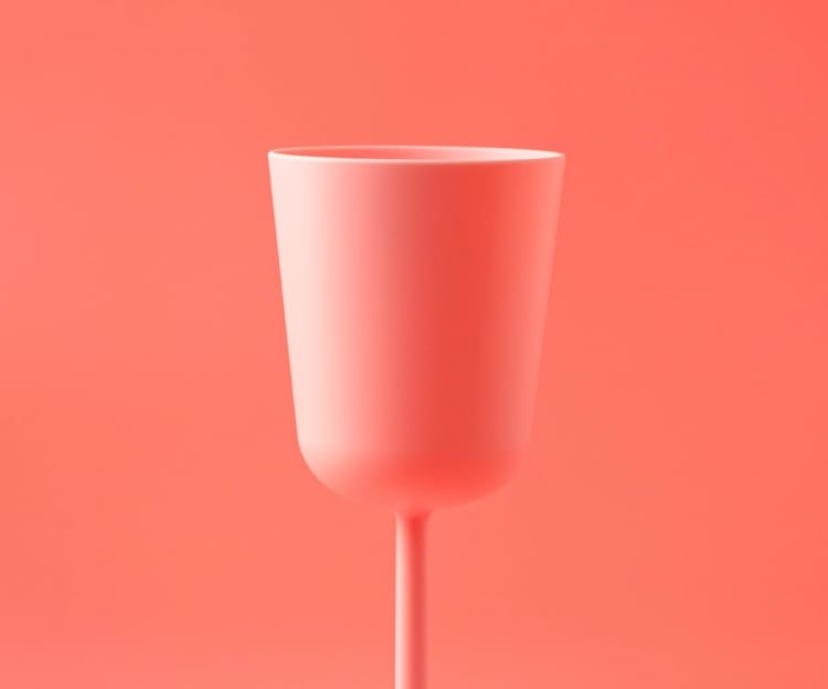 A pink cup on a stem against a coral background